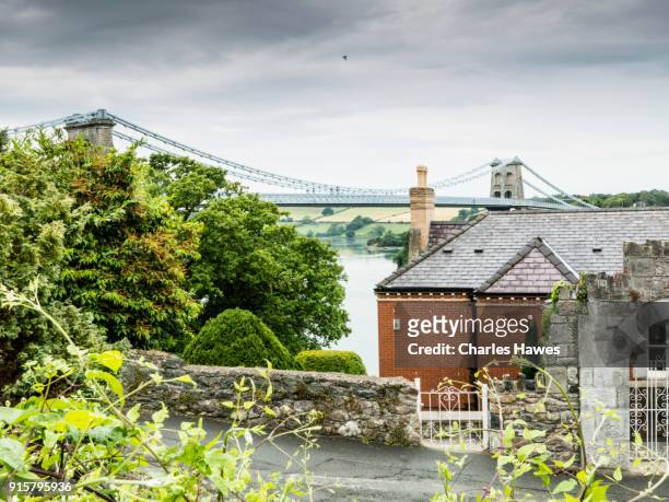 view of the menai suspension bridge (1826) designed by thomas telford from near bangor:the wales coast path - north wales - telford stock pictures, royalty-free photos & images