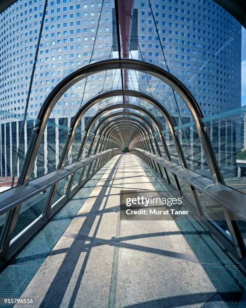 modern glass covered footbridge in la defense - voetgangersbrug stockfoto's en -beelden