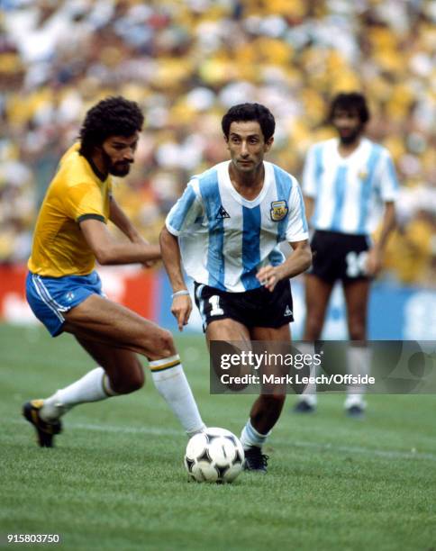 July 1982 Barcelona : FIFA World Cup : Argentina v Brazil : Osvaldo Ardiles of Argentina takes the ball past Socrates .