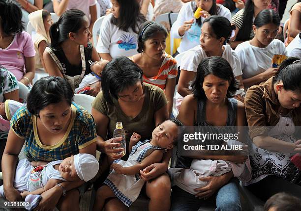 Philippines-flood-baby,FOCUS by Jason Gutierrez Pregnant women affected by floods brought about by Typhoon Ketsana hold their children as they wait...