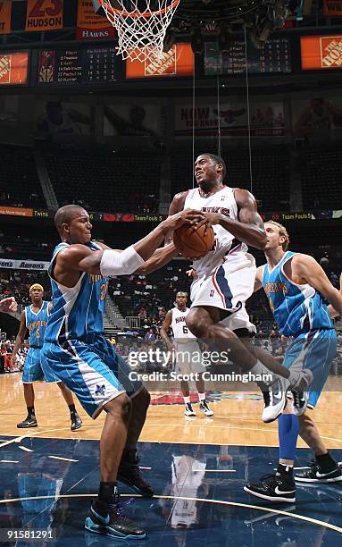 Frank Robinson of the Atlanta Hawks is tied up for a jump ball against David West of the New Orleans Hornets during a preseason game on October 7,...