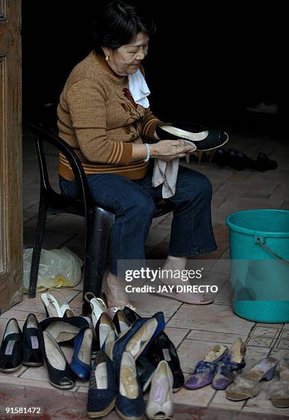 Museum official Sylvia de la Cruz cleans in Marikina City suburban Manila on October 8 some of the shoes of Imelda Marcos that were salvaged from...