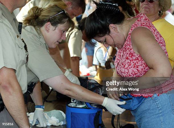 Police officer inspects a visitor's belongings at a checkpoint at the Washington Monument July 4, 2002 in Washington, D.C. Security has been tighter...