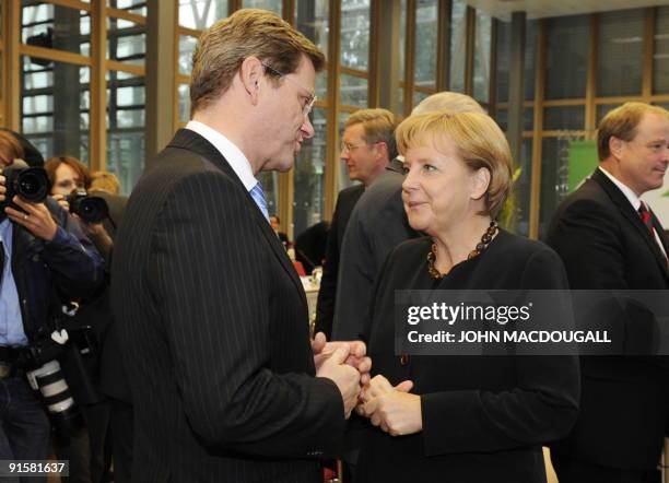 Free Democratic Party chairman Guido Westerwelle and German Chancellor Angela Merkel of the Christian Democratic Union chat prior to sitting down for...
