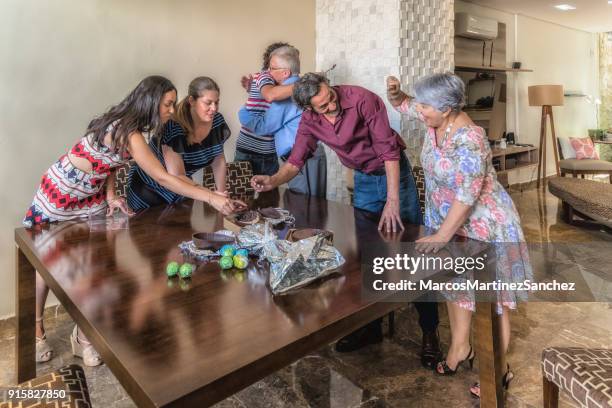 easter celebration - grandmother tasting chocolate eggs - lypsesp17 stock pictures, royalty-free photos & images