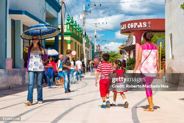 City main promenade or 'boulevard'. Woman with a blue umbrella, children and other people walking in the famous place. The ice cream parlour 'Las...