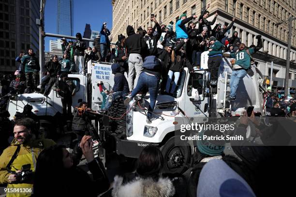 Fans fill the streets as they climb on trash trucks and celebrate with the Philadelphia Eagles during their NFL Super Bowl victory parade on February...