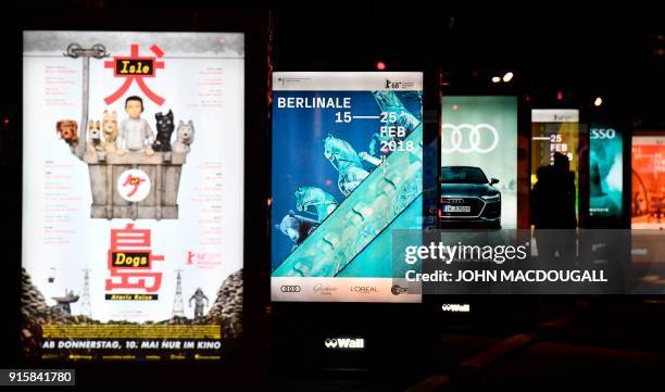 People walk past posters advertising the upcoming Berlinale film festival, including the festival's opening film "Isle of Dogs" by Wes Anderson, at...