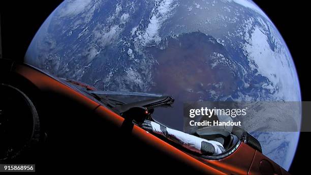 In this handout photo provided by SpaceX, a Tesla roadster launched from the Falcon Heavy rocket with a dummy driver named "Starman" heads towards...