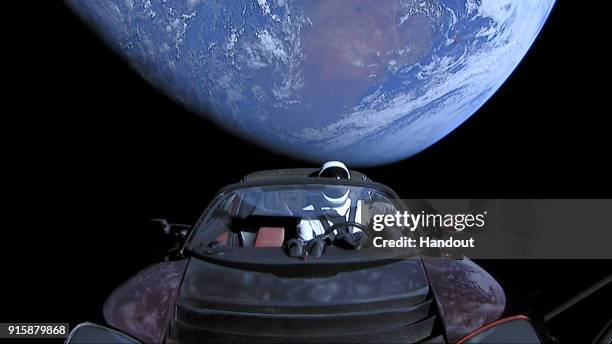 In this handout photo provided by SpaceX, a Tesla roadster launched from the Falcon Heavy rocket with a dummy driver named "Starman" heads towards...