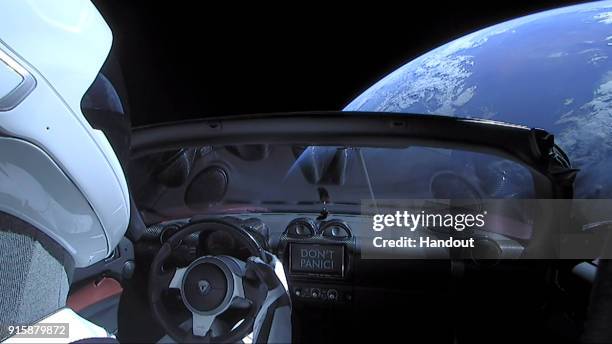 In this handout photo provided by SpaceX, a Tesla roadster launched from the Falcon Heavy rocket with a dummy driver named "Starman" heads towards...