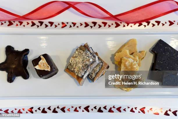 An array of unique chocolates sold at Chocolate Lab include from left to right: a pecan turtle, saffron and pear marshmallow, almond toffee, peanut...