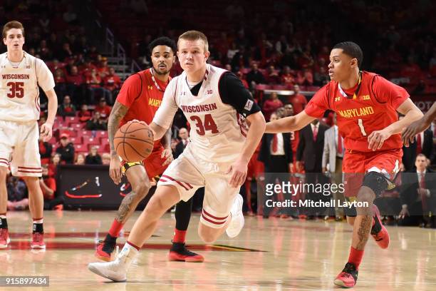 Brad Davison of the Wisconsin Badgers dribbles up court past Anthony Cowan Jr. #1 of the Maryland Terrapins during a college basketball game at...