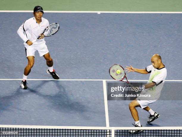 Satoshi Iwabuchi and Takao Suzuki of Japan return a shot against Jo-Wilfried Tsonga of France and Stanislas Wawrinka of Switzerland in their doubles...