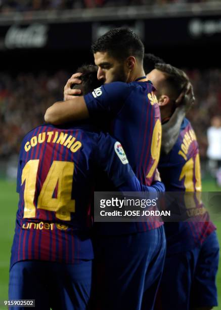 Barcelona's Uruguayan forward Luis Suarez kisses Barcelona's Brazilian midfielder Philippe Coutinho to congratulate him for his goal during the...