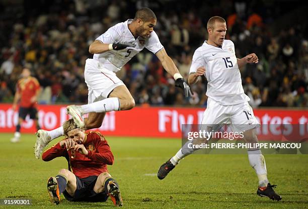 Defender Oguchi Onyewu and US defender Jay DeMerit fight for the ball with Spanish forward Fernando Torres during the Fifa Confederations Cup...