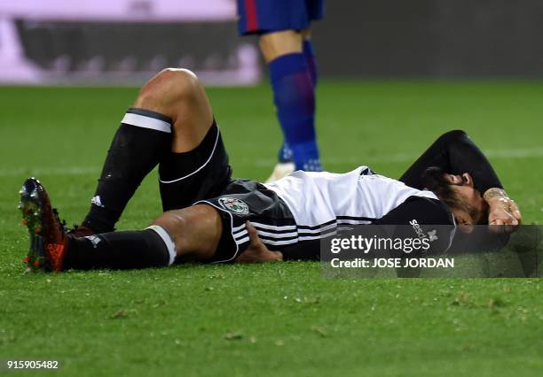 Valencia's Argentinian defender Ezequiel Garay lies on the field after resulting injured during the Spanish 'Copa del Rey' second leg semi-final...