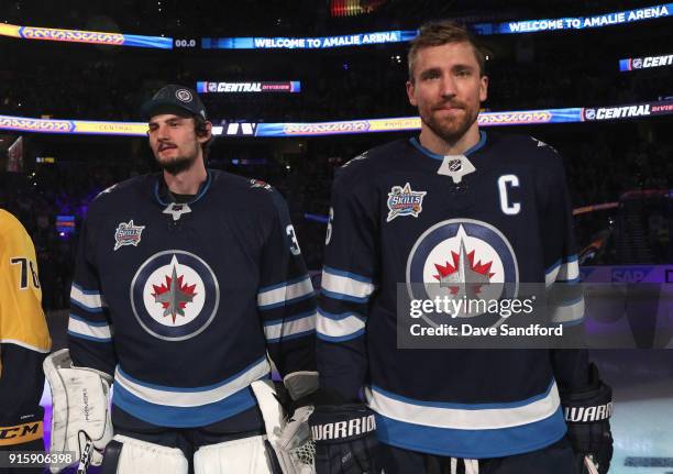 Goaltender Connor Hellebuyck and Blake Wheeler of the Winnipeg Jets stand on the ice before the 2018 GEICO NHL All-Star Skills Competition at Amalie...