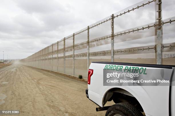 a border fence stands along the u.s.-mexico border - 地理的境界 ストックフォトと画像