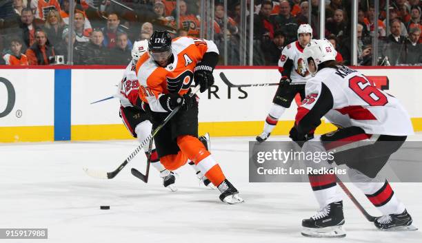 Wayne Simmonds of the Philadelphia Flyers skates the puck between Johnny Oduya and Erik Karlsson of the Ottawa Senators on February 3, 2018 at the...