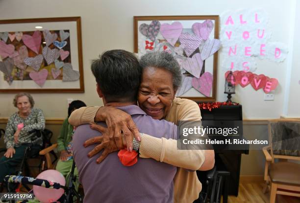 Chelsea Place resident Gwen Sowell, right, gives a hug to Craig Dauer, a certified occupational therapy assistant, left, as the two dance and take...