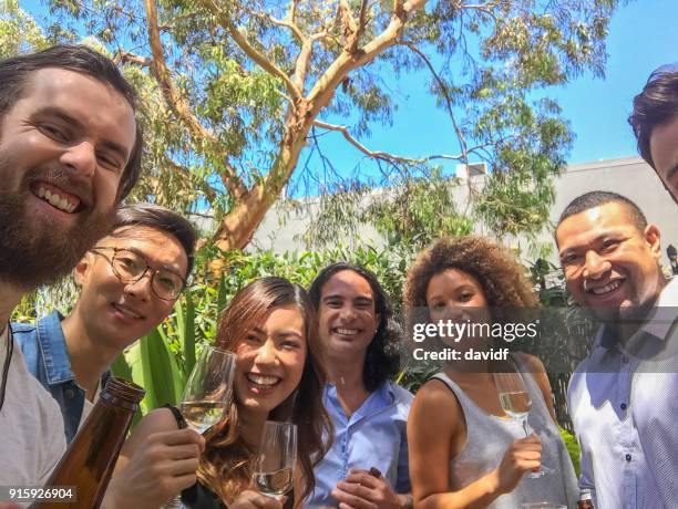 group of mixed race people taking a selfie at a christmas party - sydney christmas lights 2017 stock pictures, royalty-free photos & images