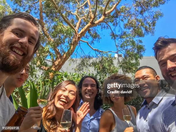 group of mixed race people taking a selfie at a christmas party - sydney christmas lights 2017 stock pictures, royalty-free photos & images