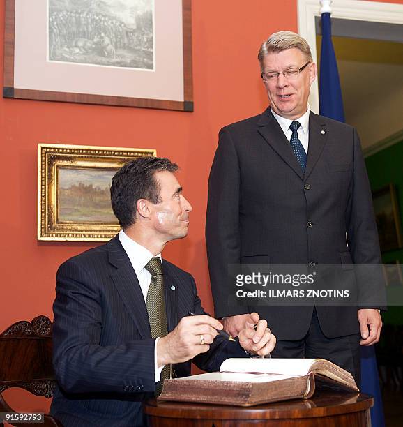 Secretary General Anders Fogh Rasmussen signs a guest book after a joint press conference with Latvian President Valdis Zatlers on October 8, 2009 in...