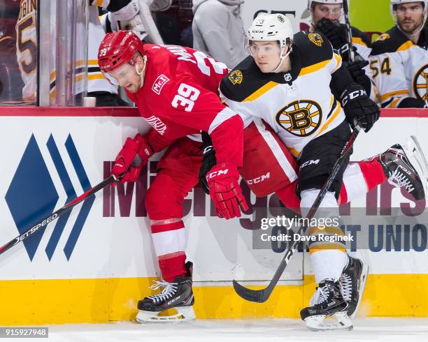 Anthony Mantha of the Detroit Red Wings battles along the boards with with Charlie McAvoy of the Boston Bruins during an NHL game at Little Caesars...