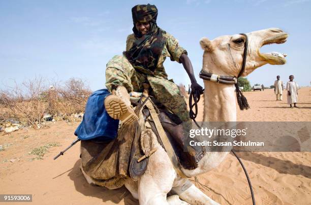 The SLA , signatories of the DPA , control this Zam Zam IDP camp. Here one of their commanders dismounts froma camel. They work with UNAMID to ensure...