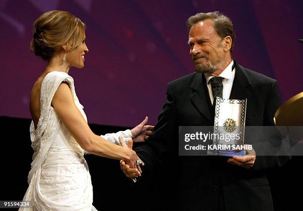 Actress Hilary Swank shakes hands with Italian actor Franco Nero, after he received on behalf of his wife British actress Vanessa Redgrave, a...