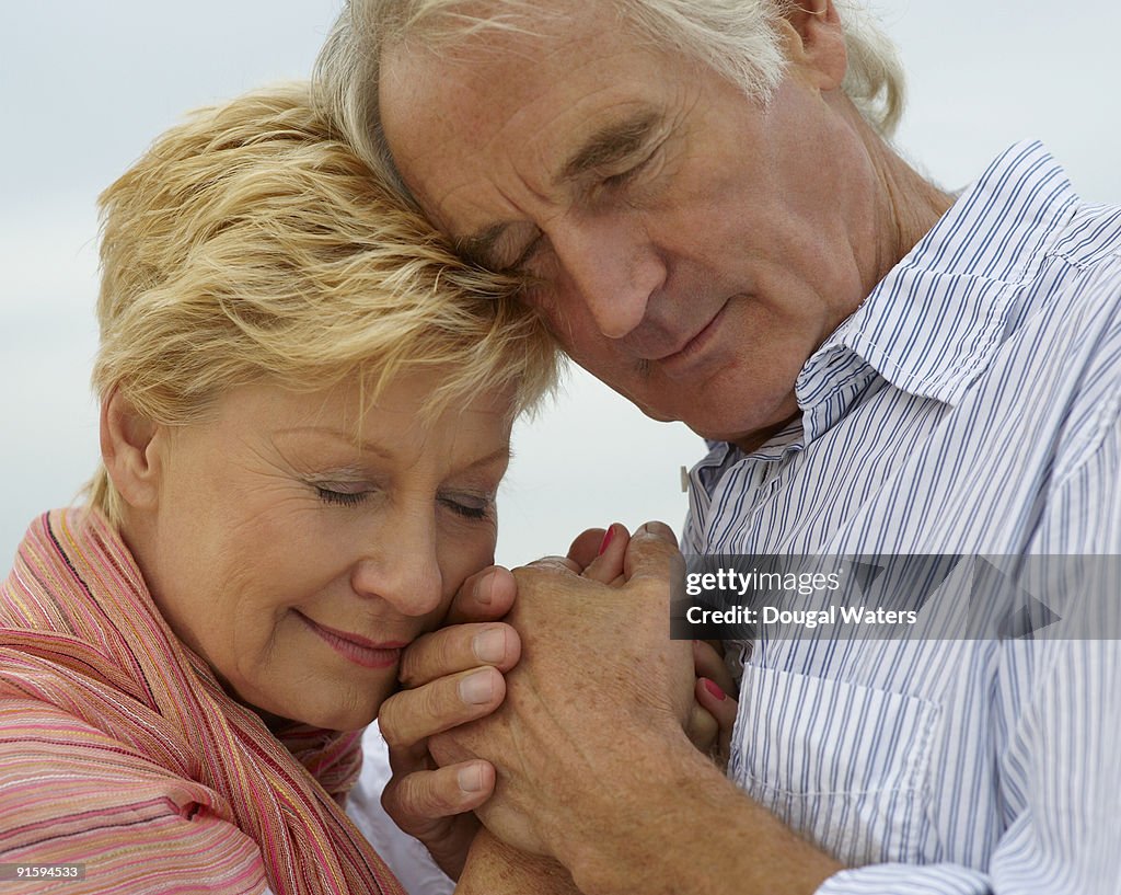 Elderly couple embracing one another.