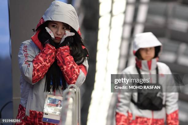 Volunteer uses hand warmers at the Olympic Sliding Centre ahead of the Pyeongchang 2018 Winter Olympic Games in Pyeongchang on February 8, 2018. /...