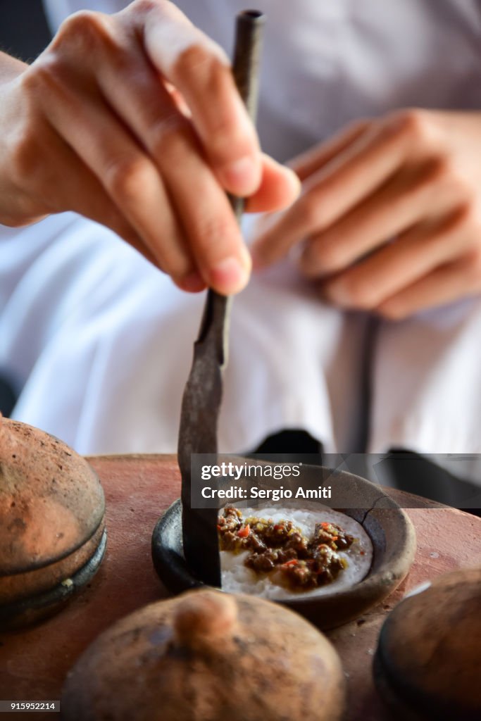 Removing a Bánh Bèo, Vietnamese savory rice tea cake from its baking mould using a spatula