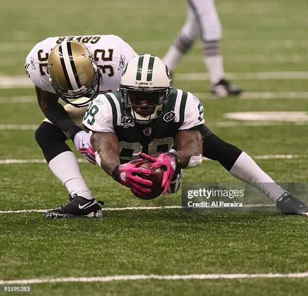 Wide Receiver Jerricho Cotchery of the New York Jets makes a catch and stretches for a first down while being covered by Cornerback Jabari Greer of...