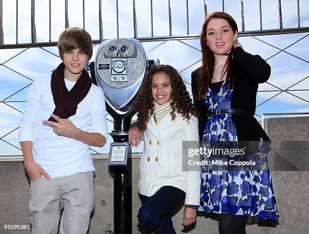 Singer Justin Bieber, actress Madison Pettis, and actress Jennifer Stone pose at the The Empire State Building in honor of Jumpstart's 4th Annual...