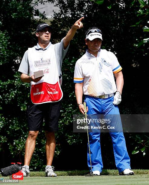 Yang of Korea and caddie A.J. Montecinos look on during the first round of THE TOUR Championship presented by Coca-Cola, the final event of the PGA...