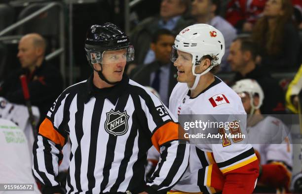 Matthew Tkachuk of the Calgary Flames and referee Kevin Pollock chat during the game against the New Jersey Devils at Prudential Center on February...