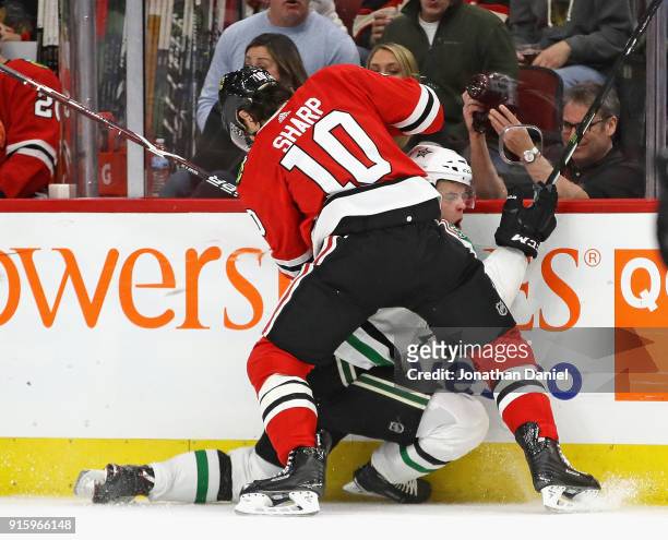 Patrick Sharp of the Chicago Blackhawks pins Julius Honka of the Dallas Stars against the boards as htye battle for the puck at the United Center on...