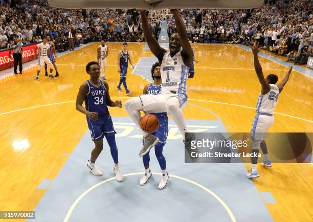 Theo Pinson of the North Carolina Tar Heels dunks the ball as teammates Wendell Carter Jr and Marvin Bagley III of the Duke Blue Devils watch on...