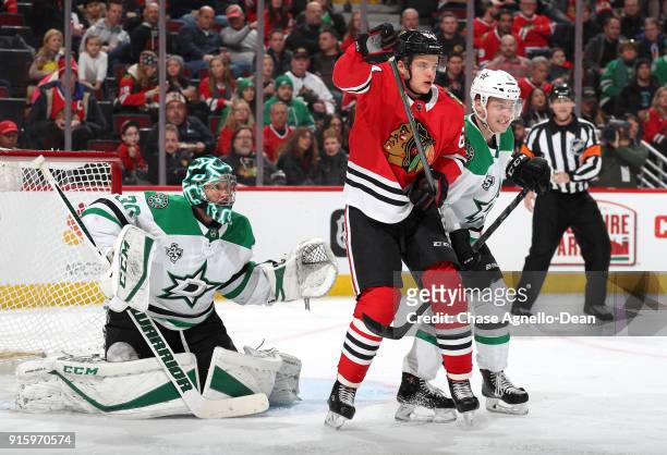 David Kampf of the Chicago Blackhawks and Julius Honka of the Dallas Stars watch for the puck in front of goalie Ben Bishop in the second period at...