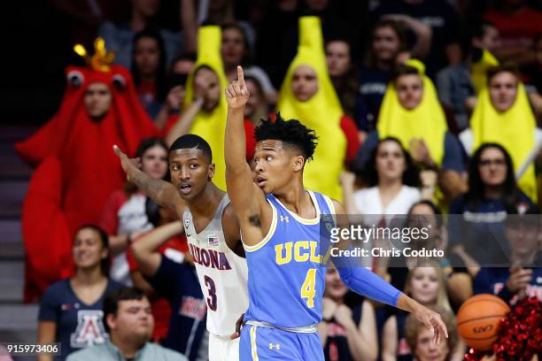 Dylan Smith of the Arizona Wildcats and Jaylen Hands of the UCLA Bruins gesture after the ball went out of bounds during the first half of the...