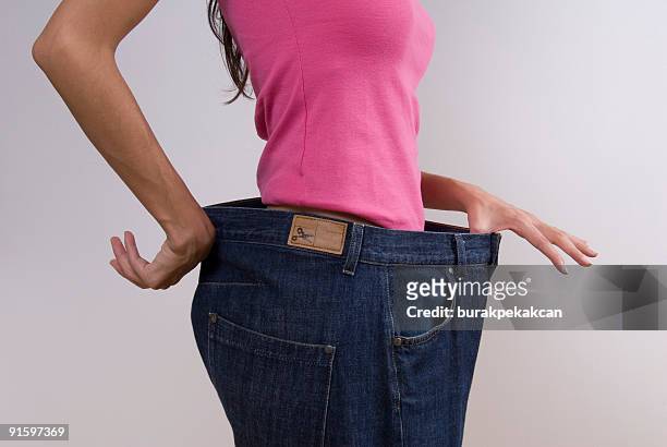 woman wearing jeans amplio - demasiado grande fotografías e imágenes de stock