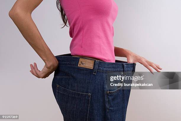 woman wearing large jeans - 特大 個照片及圖片檔