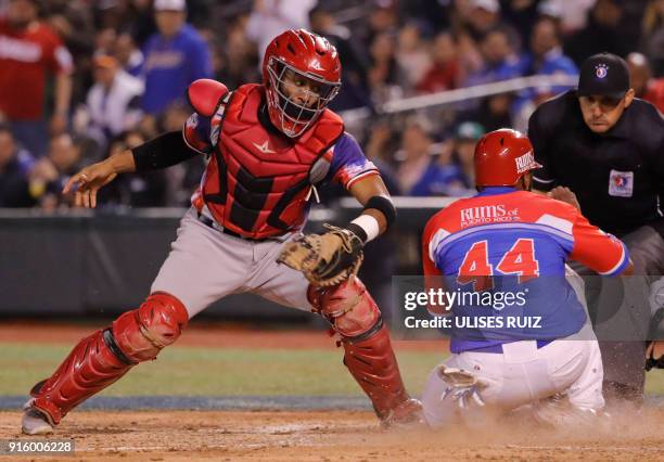 Anthony Garcia of Criollos de Caguas of Puerto Rico arrives safe at home in front of catcher Carlos Paulino of Aguilas Cibaenas of Republica...