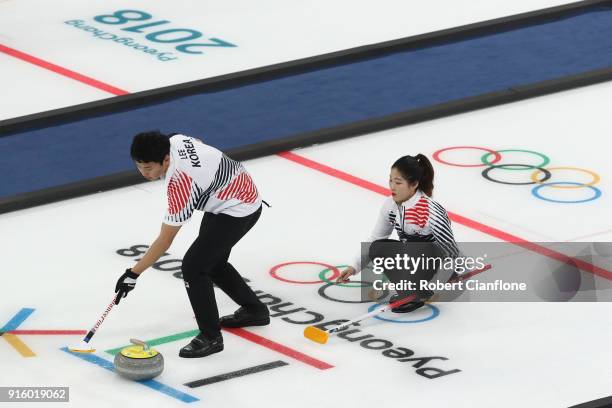 Kijeong Lee and Hyeji Jang of Korea deliver a stone against Becca Hamilton and Matt Hamilton of the United States during the Curling Mixed Doubles...