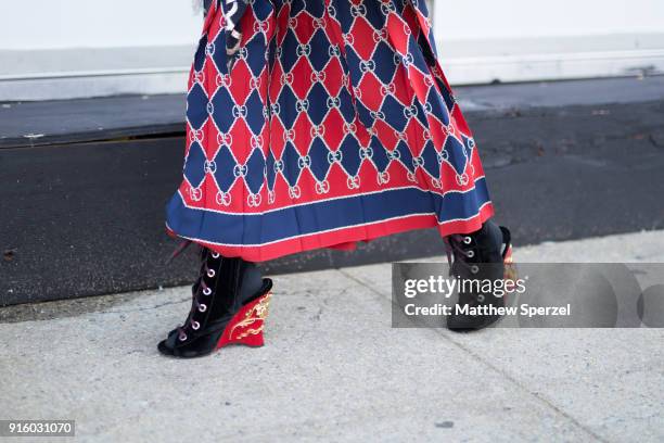 Guest is seen on the street attending Colovos and Noon By Noor during New York Fashion Week wearing a fringe fur coat with red and navy skirt and...