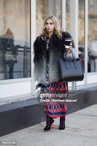 Guest is seen on the street attending Colovos and Noon By Noor during New York Fashion Week wearing a fringe fur coat with red and navy skirt and...