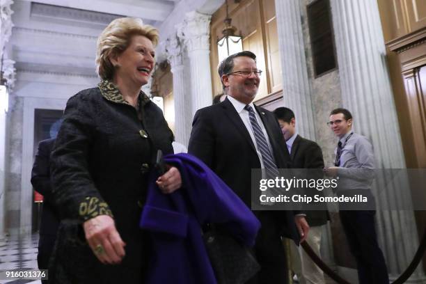 Sen. Debbie Stabenow and Sen. Gary Peters make their way to the Senate Chamber for early morning votes at the U.S. Capitol February 9, 2018 in...