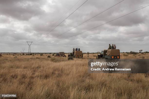 Members of an elephant collaring team wait for elephants to be spotted by the rest of the team in the air before moving to a new location during an...